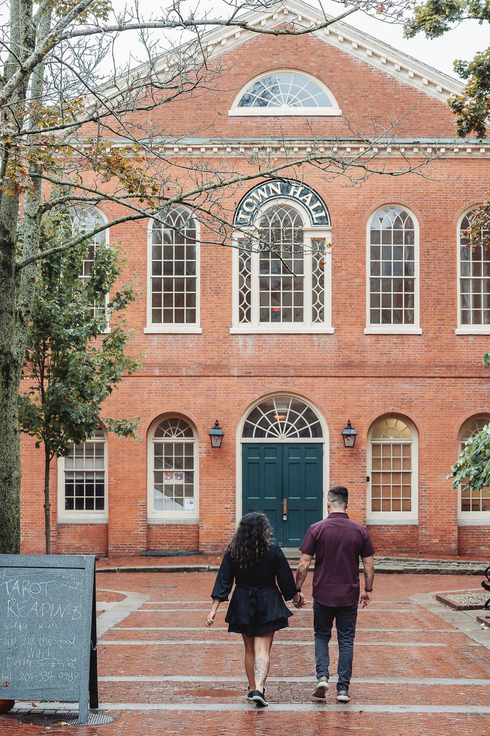 A couple walking towards a historic brick building with Georgian architecture.