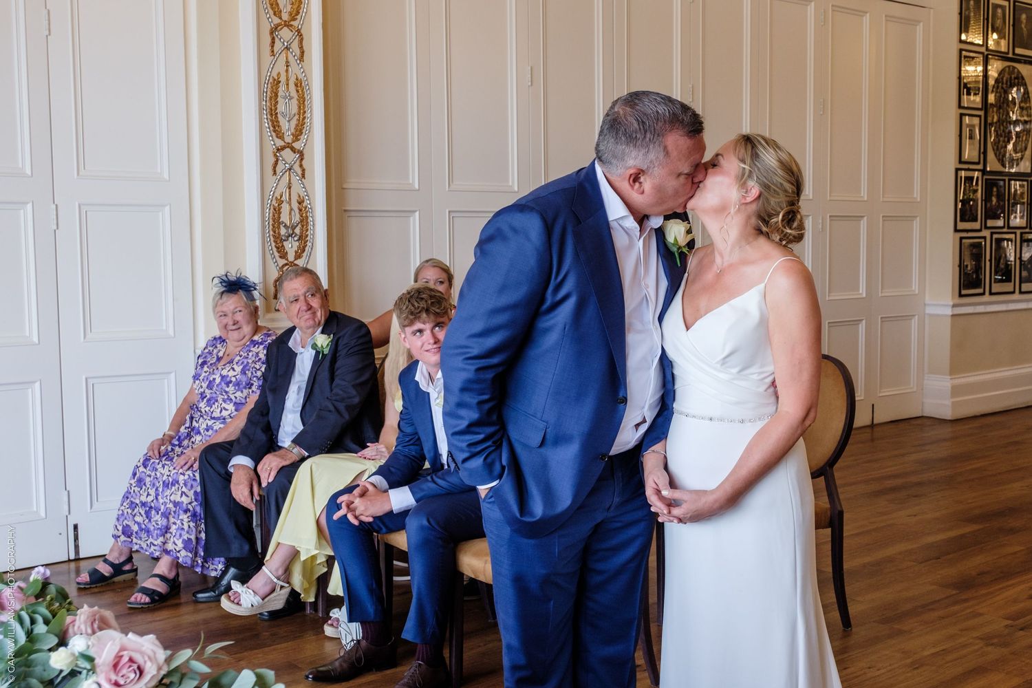 Candid wedding photo series with white paneled walls showing intimate moments between couples during a celebration.
