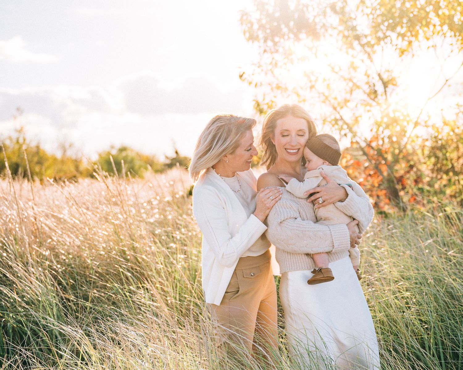 Family enjoying golden hour sunset in a field of tall grass.