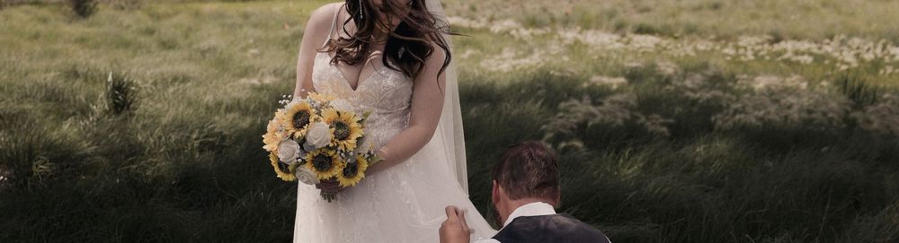 A couple embraces outdoors during their golden hour wedding celebration amid natural scenery.