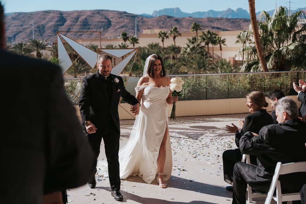 Wedding ceremony taking place at Red Rock Canyon with mountains and desert landscape in the background.
