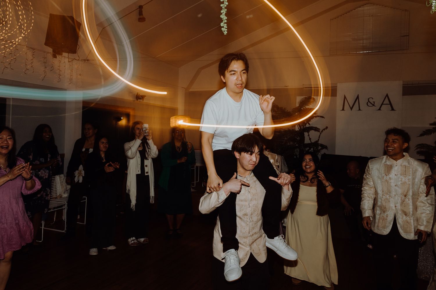 Dancers performing acrobatic moves during an indoor celebration with ambient lighting.