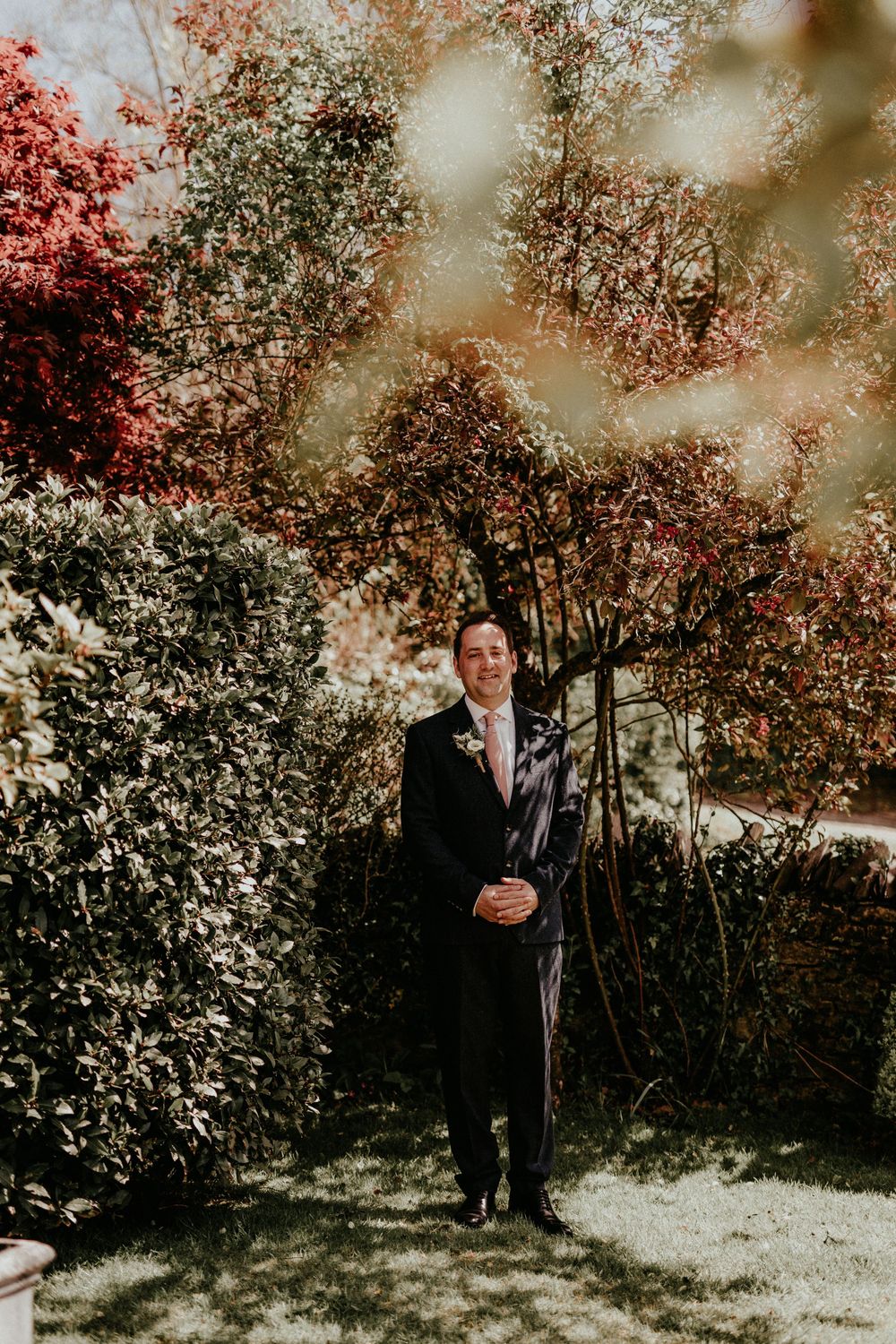 An autumn wedding scene with vibrant red and white foliage in the background under warm natural lighting.