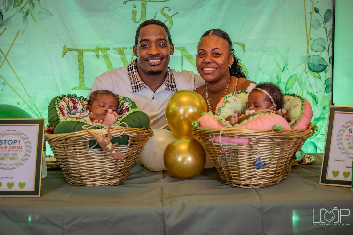 Event display featuring golden balloons and decorative gift baskets against a mint green backdrop.