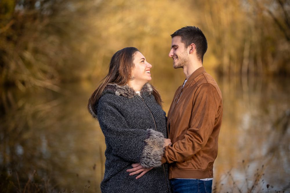 Couple sharing a tender moment on a nature trail surrounded by fall foliage.