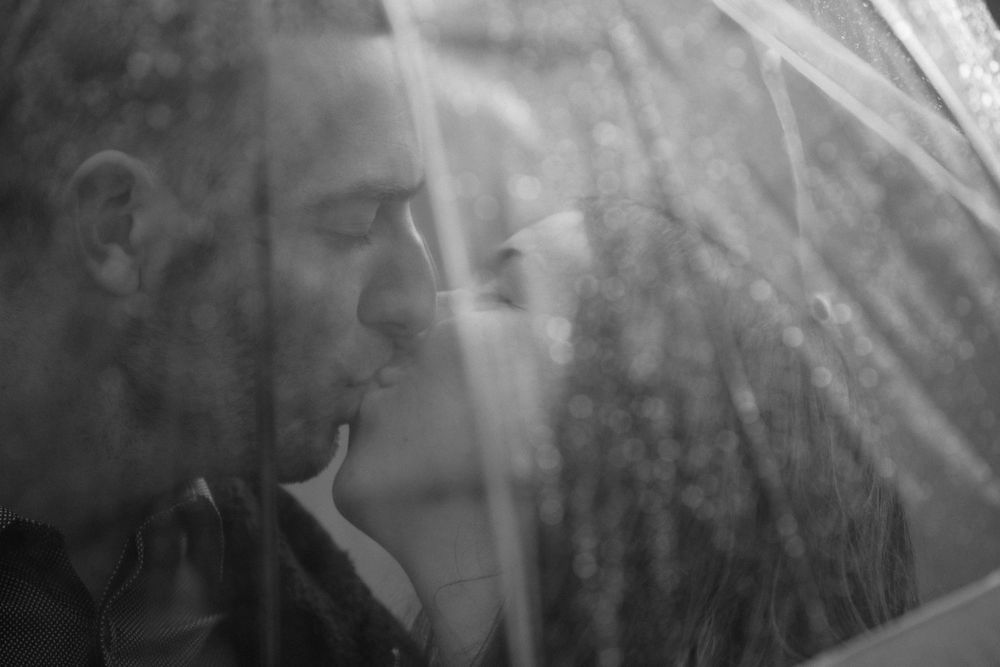 Artistic black and white profile portrait through glass with ethereal light and shadows.