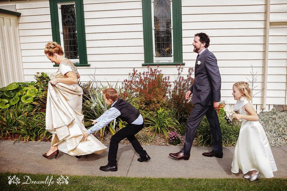 Series of fun and playful wedding party photos showing the group striking choreographed poses outside a white building with green trim.
