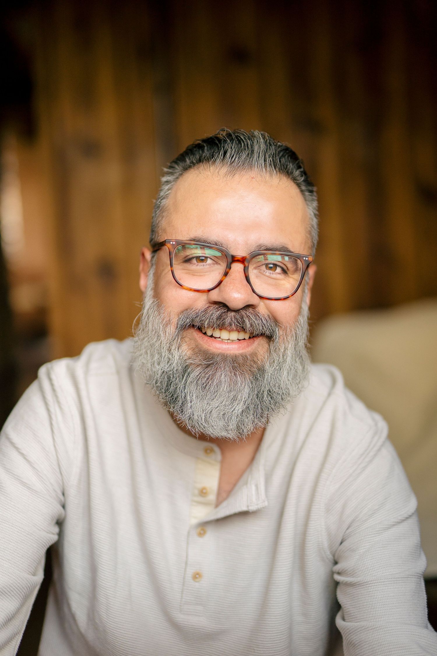 Series of warm portraits showing progressive smiles and expressions against a wooden backdrop.