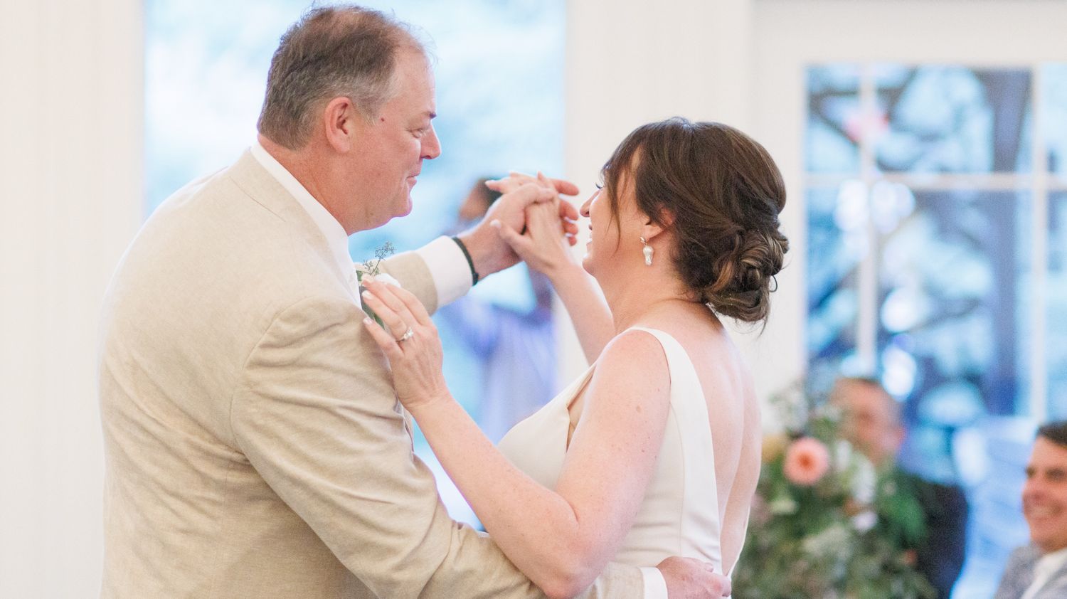 Indoor wedding ceremony in a modern industrial venue with white walls and exposed ceiling.