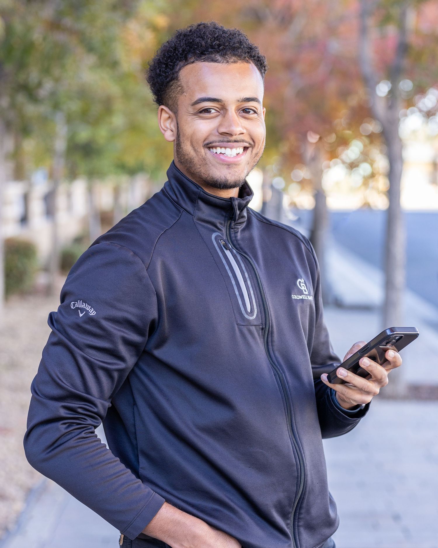 Male poses outside of business in Lancaster, CA for professional headshot. Professional photographer works on posing male.