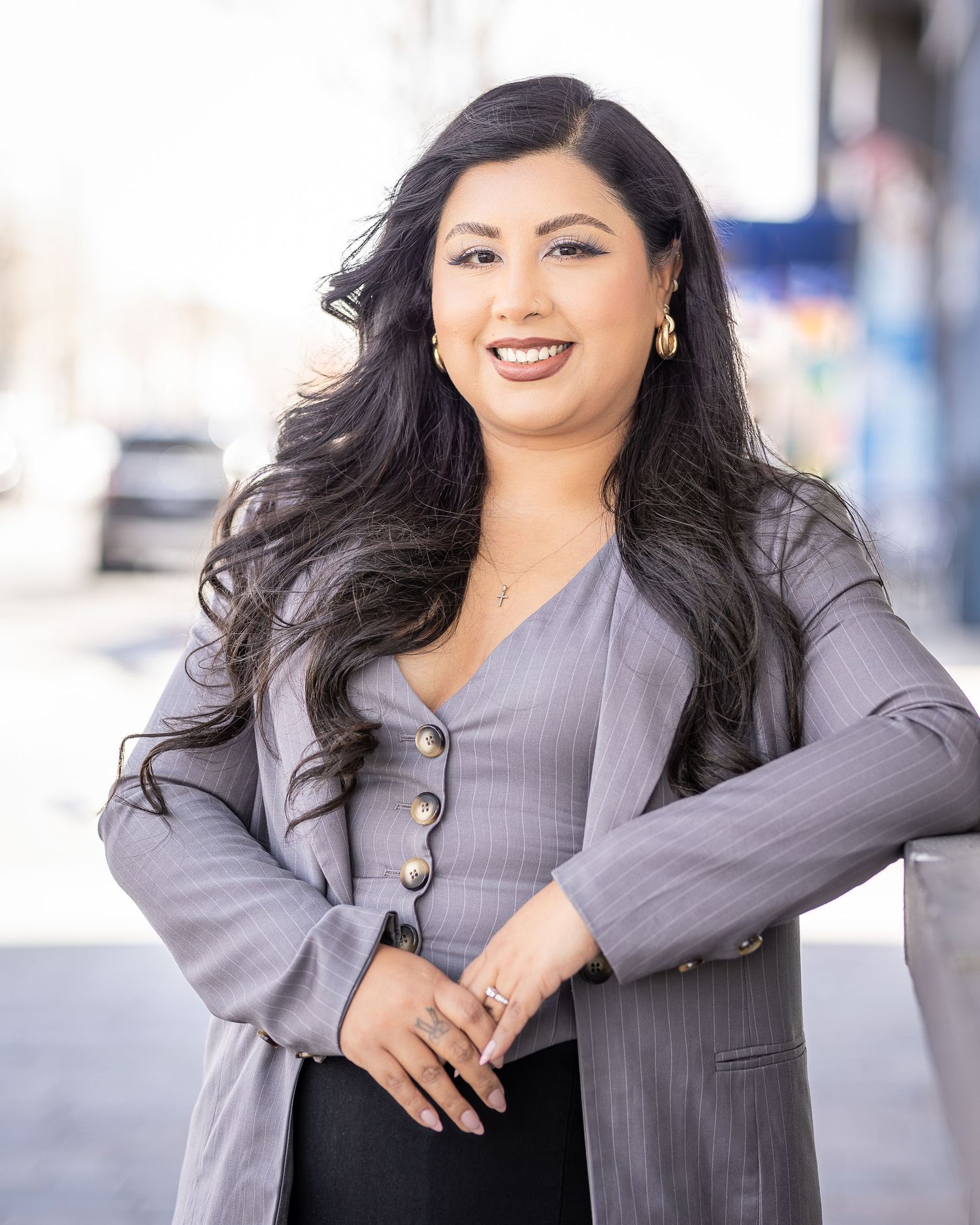 Business headshot of a women in Lancaster, CA poses outside of business. Professional Photographer assists in posing model for headshot.