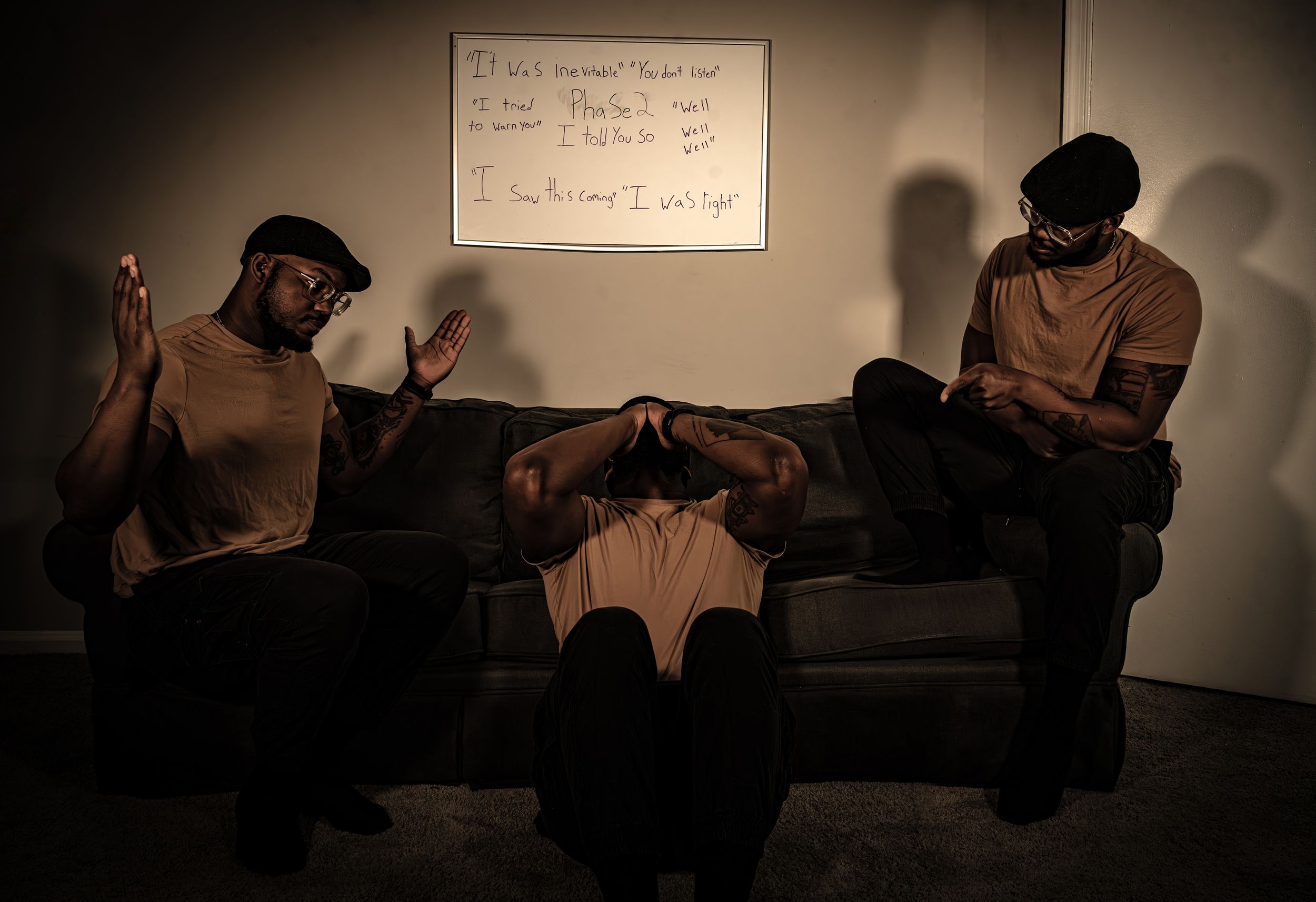 Multiple people seated in a dark room illuminated by the glow of their phone screens.