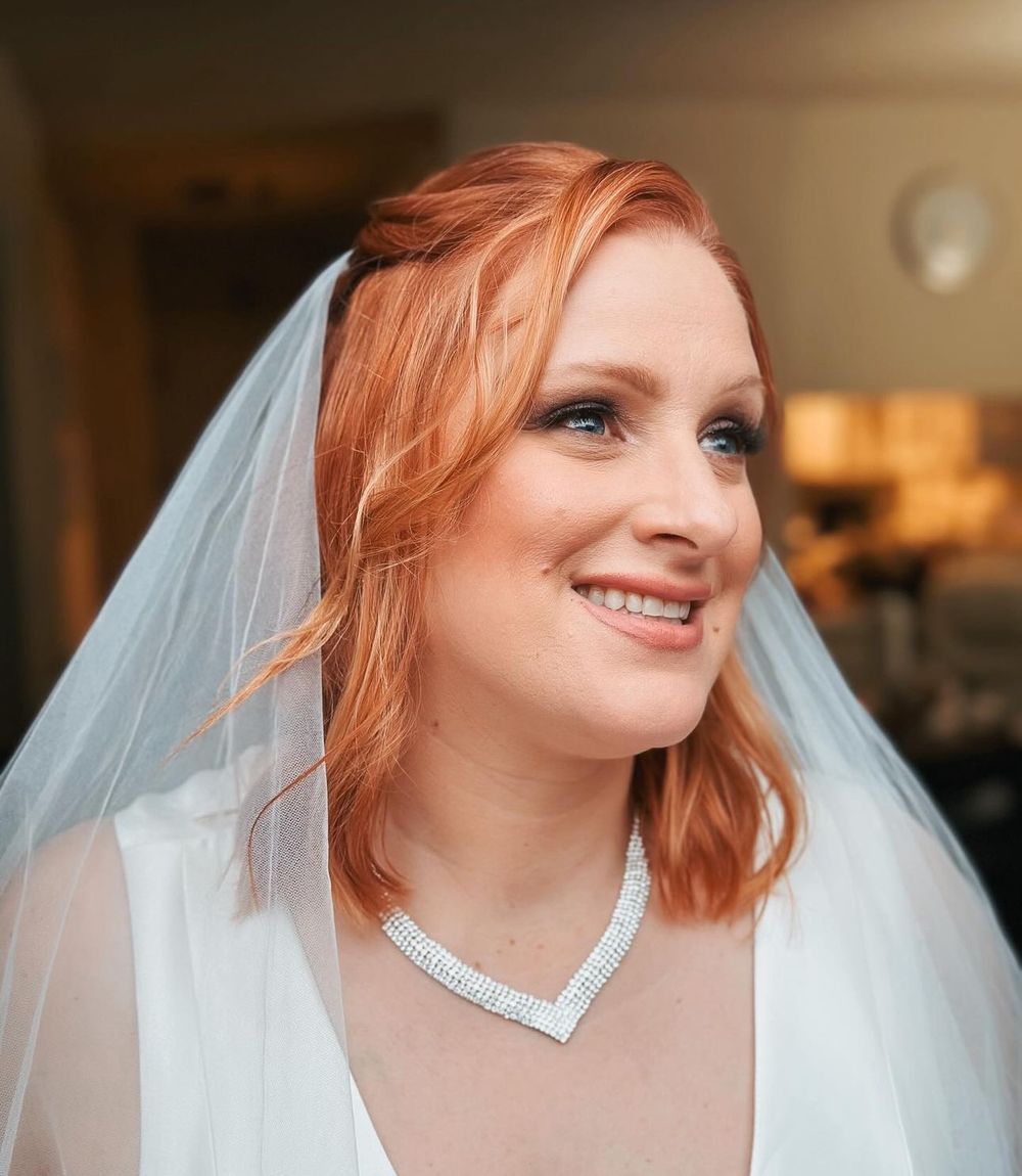 Bridal portrait featuring red hair, veil and crystal necklace.