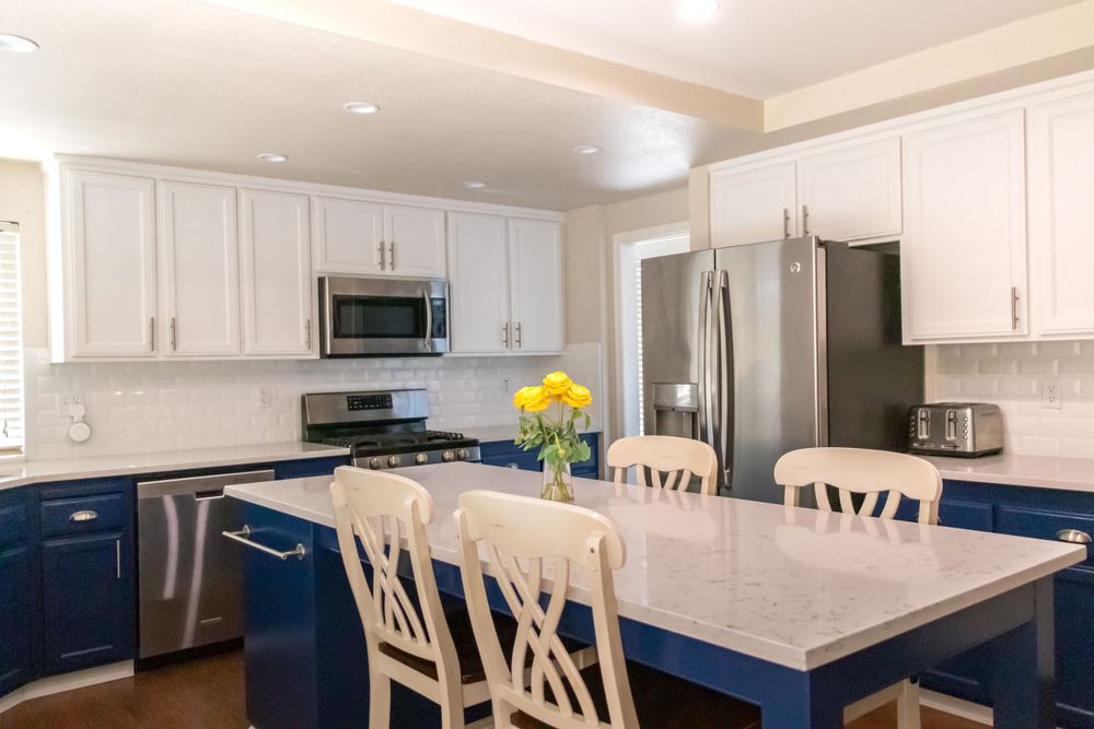 Renovated kitchen featuring two-tone cabinets, granite countertops and modern stainless appliances.
