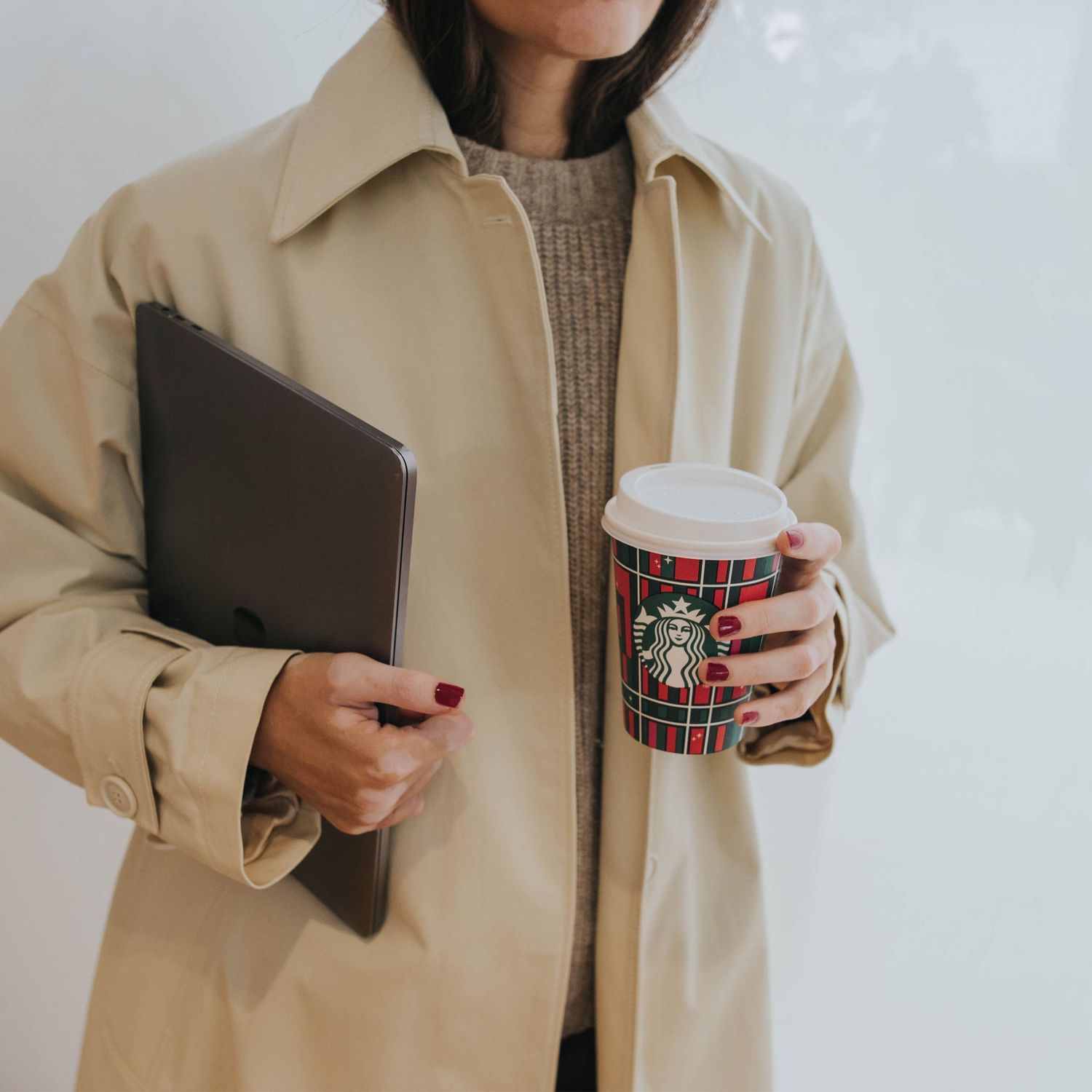 Fotografia de negocio. mujer con gabardina, tablet y vaso de cafe Starbucks en las manos. Contenido para redes sociales