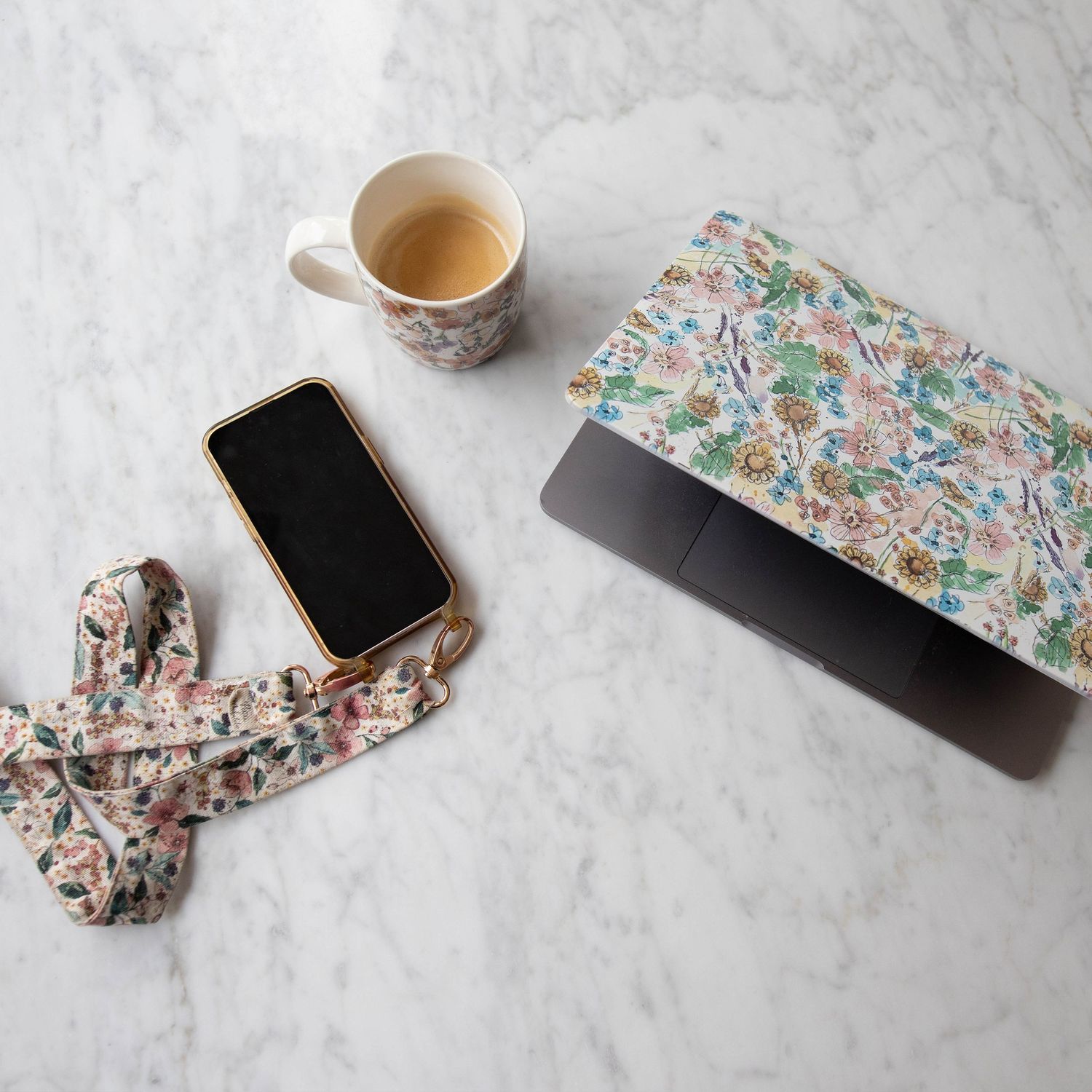 en la mesa un ordenador portátil, taza de cafe y mover. Marca Petit Mafalda y sus productos. Sesiones para marcas.