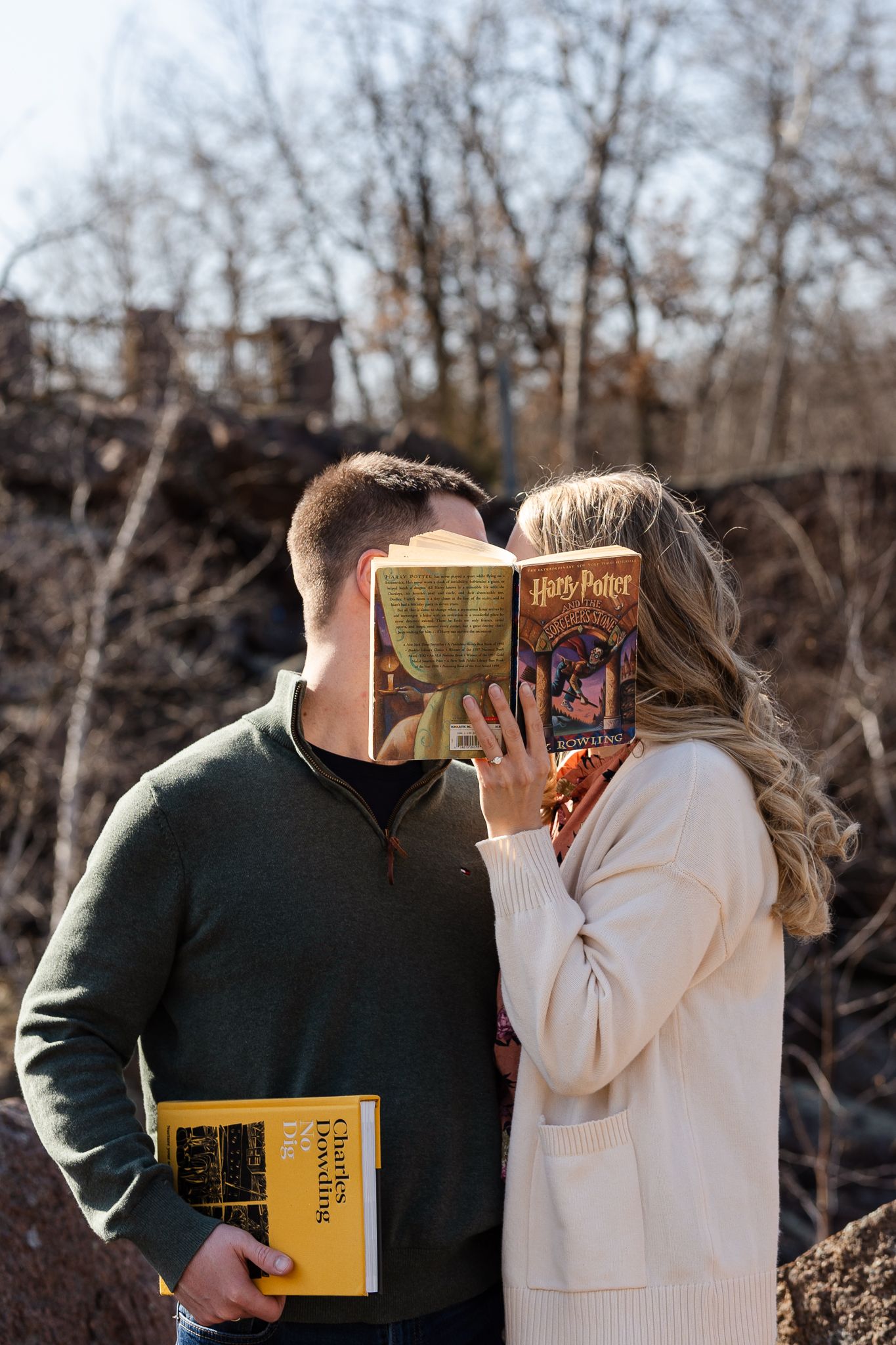 Two people share an intimate moment while reading books outdoors in autumn.