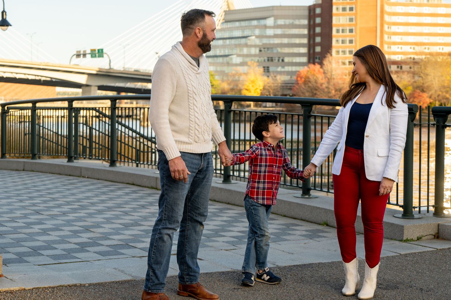Family enjoys time together while walking along an urban waterfront promenade on a sunny afternoon.