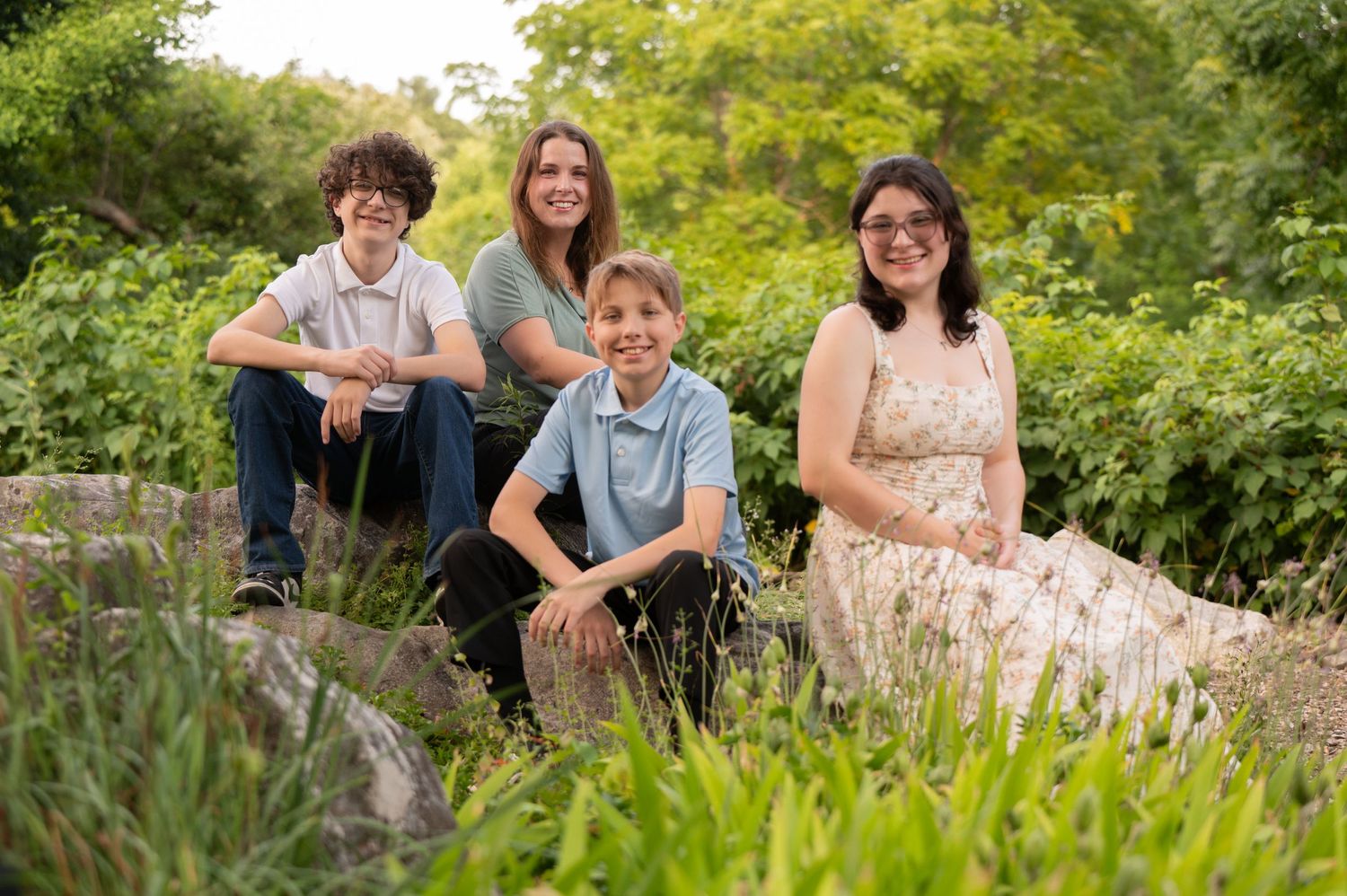 A group poses together outdoors in a beautiful garden setting with vibrant greenery. Massachusetts Family photographer Serving New England