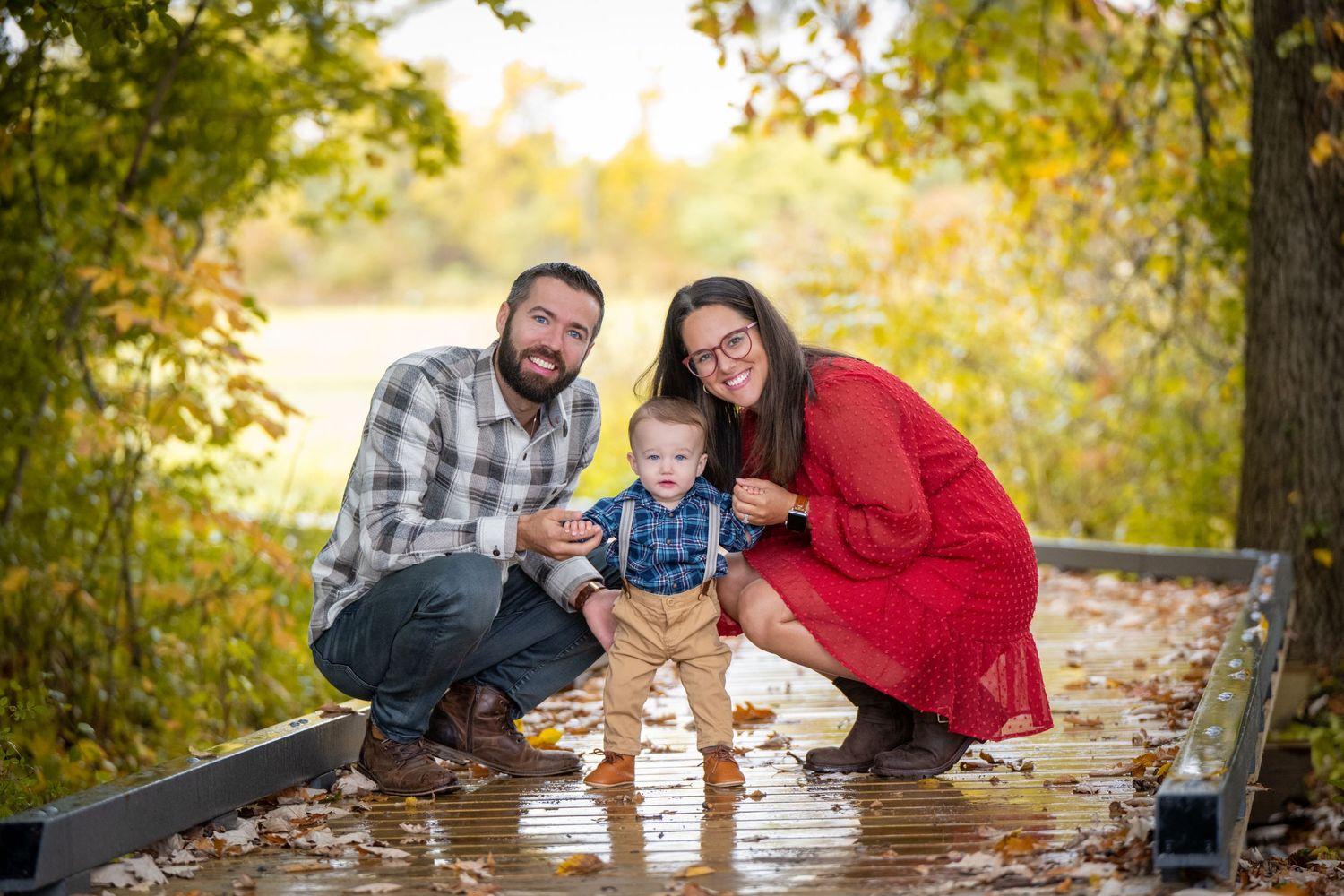 A family sits together on wooden steps during autumn, sharing a tender moment. Massachusetts Family photographer Serving New England Afford
