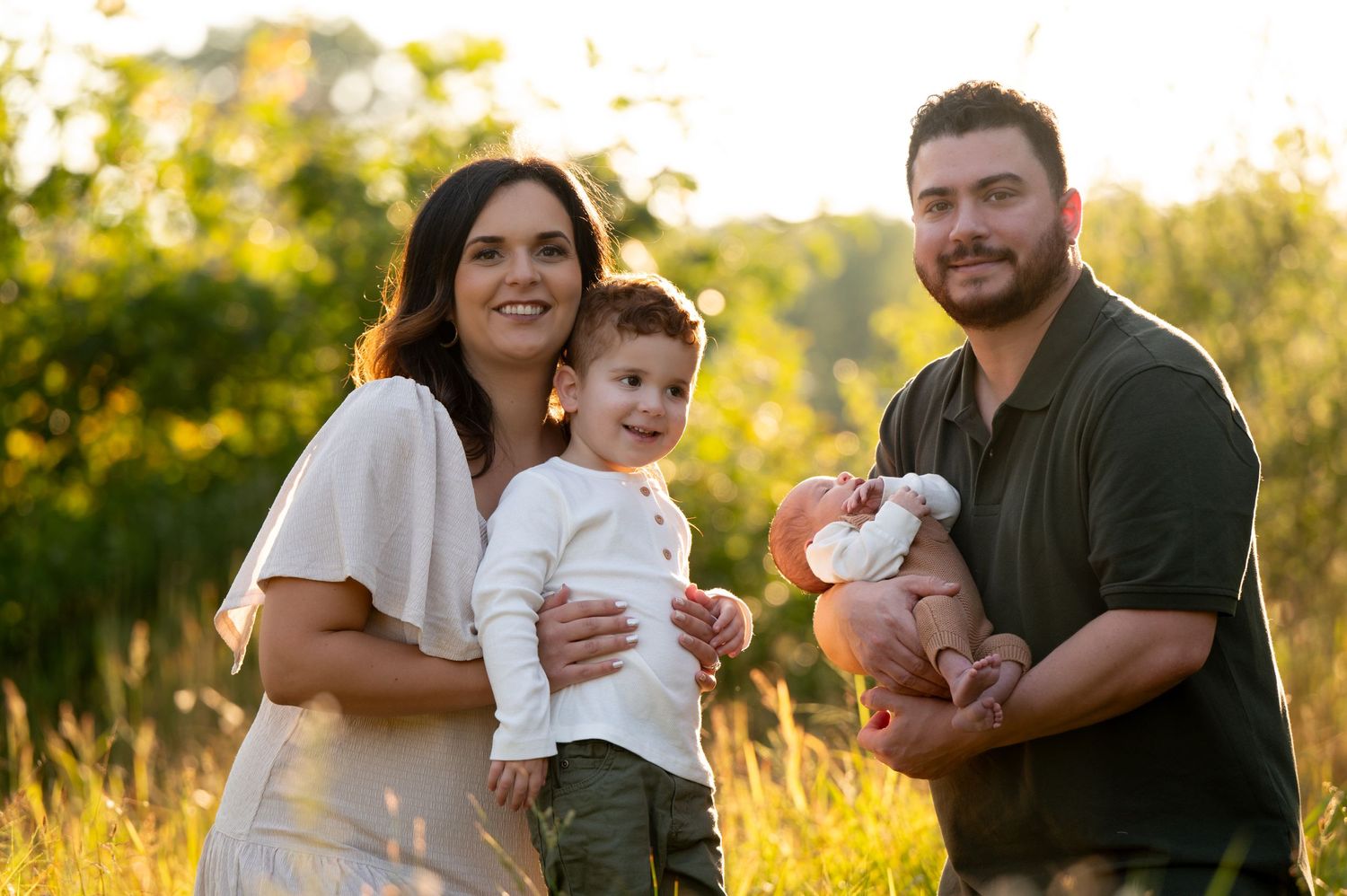 A family portrait in a sunlit field at golden hour with young children. Massachusetts Family Photographer Serving New England Affordable