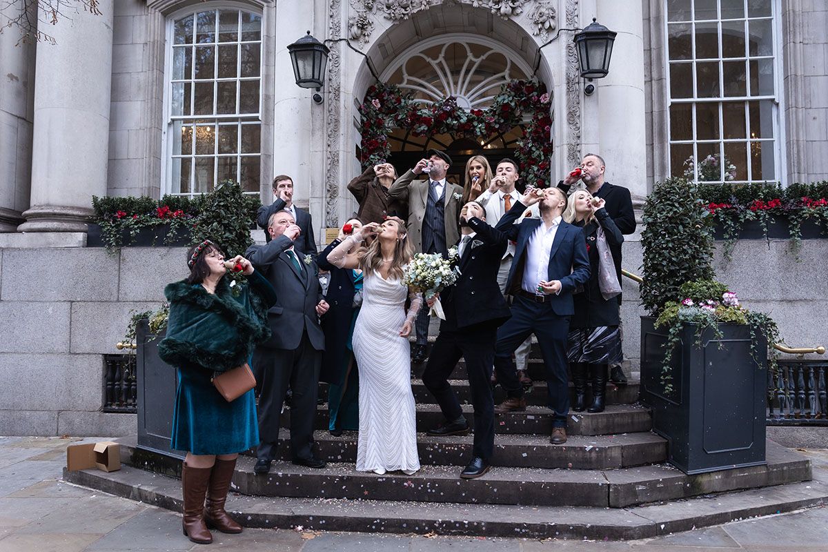 Group wedding shot of Baileys on the steps of Chelsea Old Town Hall