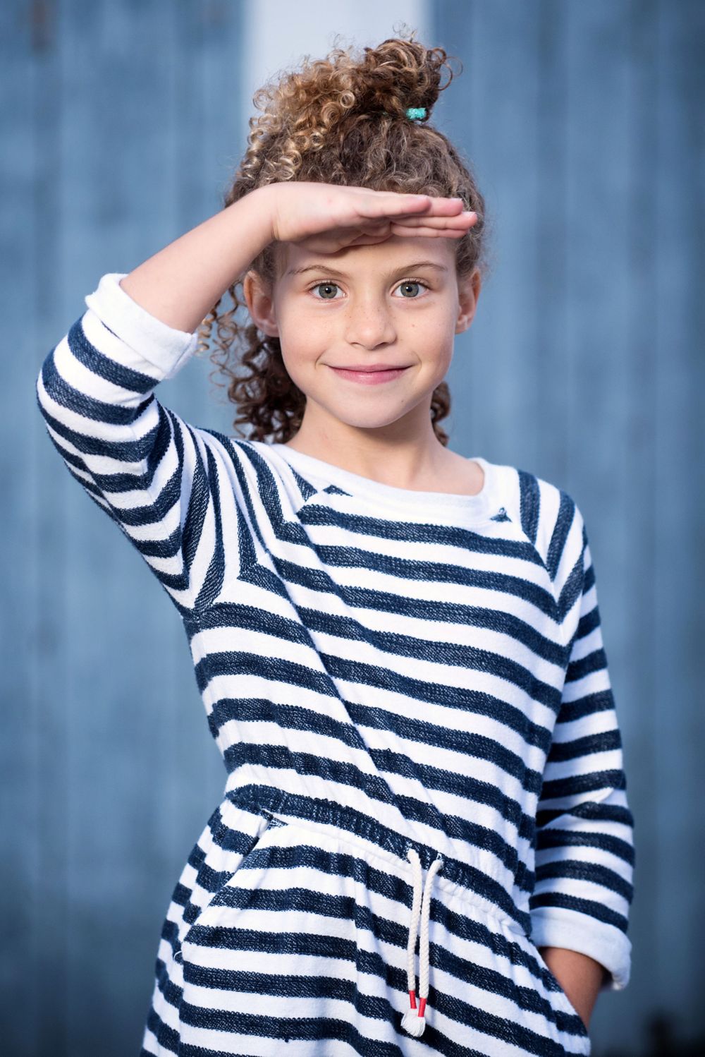 female child model wearing blue stripes and saluting