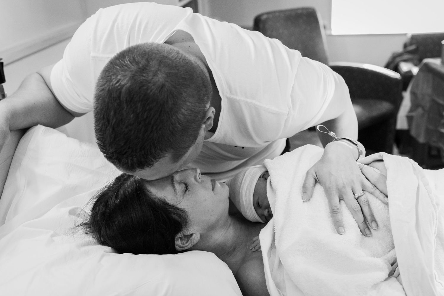 A mother holds her new baby tight to her chest moments after birth in Lafayette Colorado