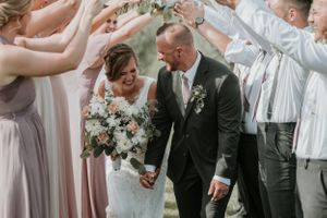 Bride and groom walking through a tunnel of their wedding party