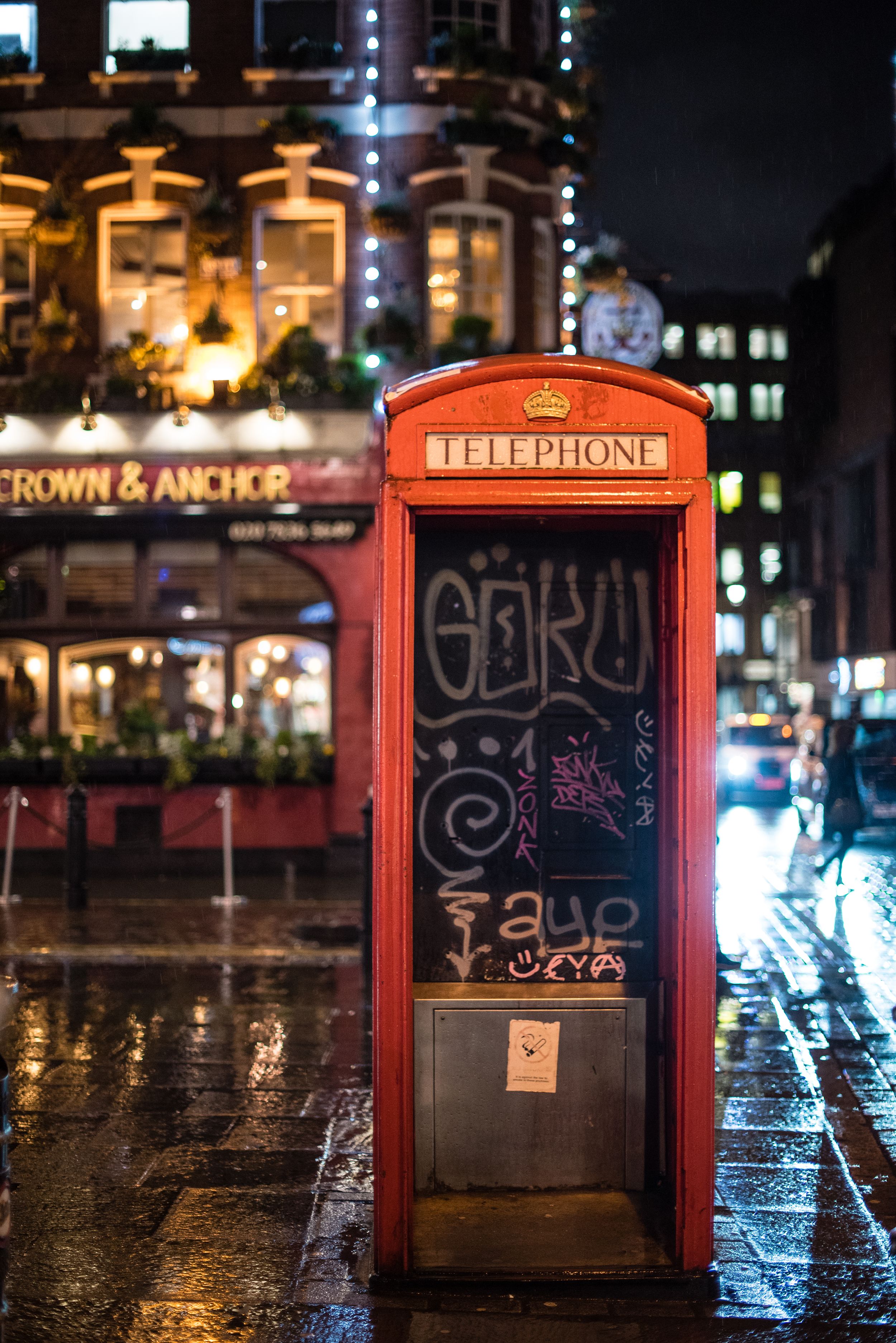 London's famous red telephone booth on a rainy night at Crown & Anchor