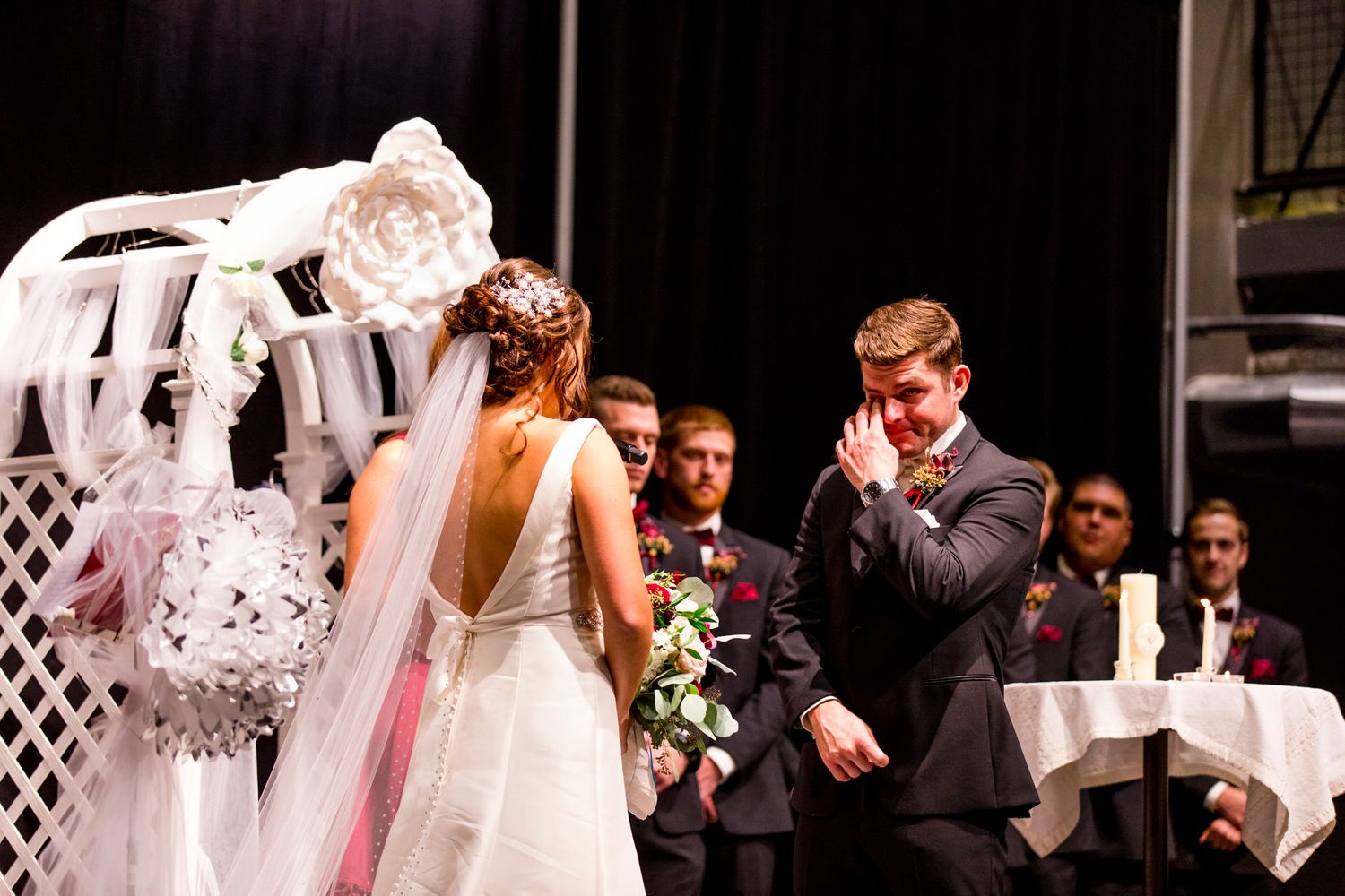chicago couple wipes tears on fall wedding ceremony under white arch