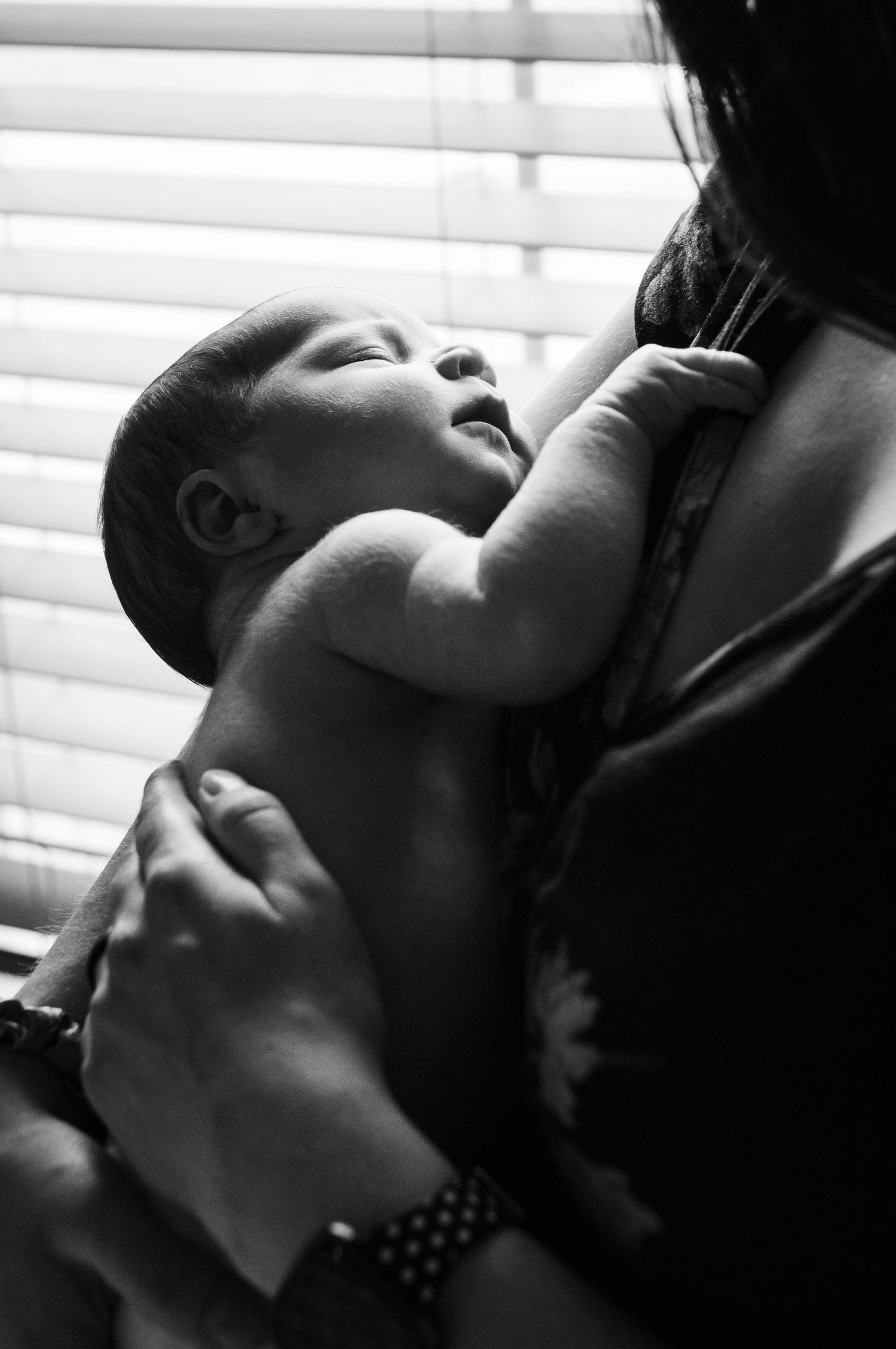 Newborn sleeping against mama's chest during their Erie, Colorado newborn photography session by Erie CO photographer