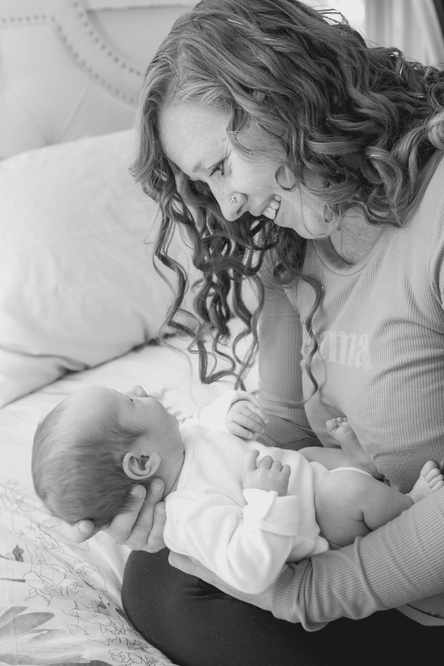 Mama looking down at her newborn son in black and white, during a Longmont, Coloradonewborn session