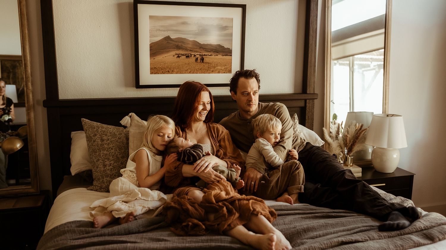 A family snuggles on their bed during their newborn session in Erie Colorado