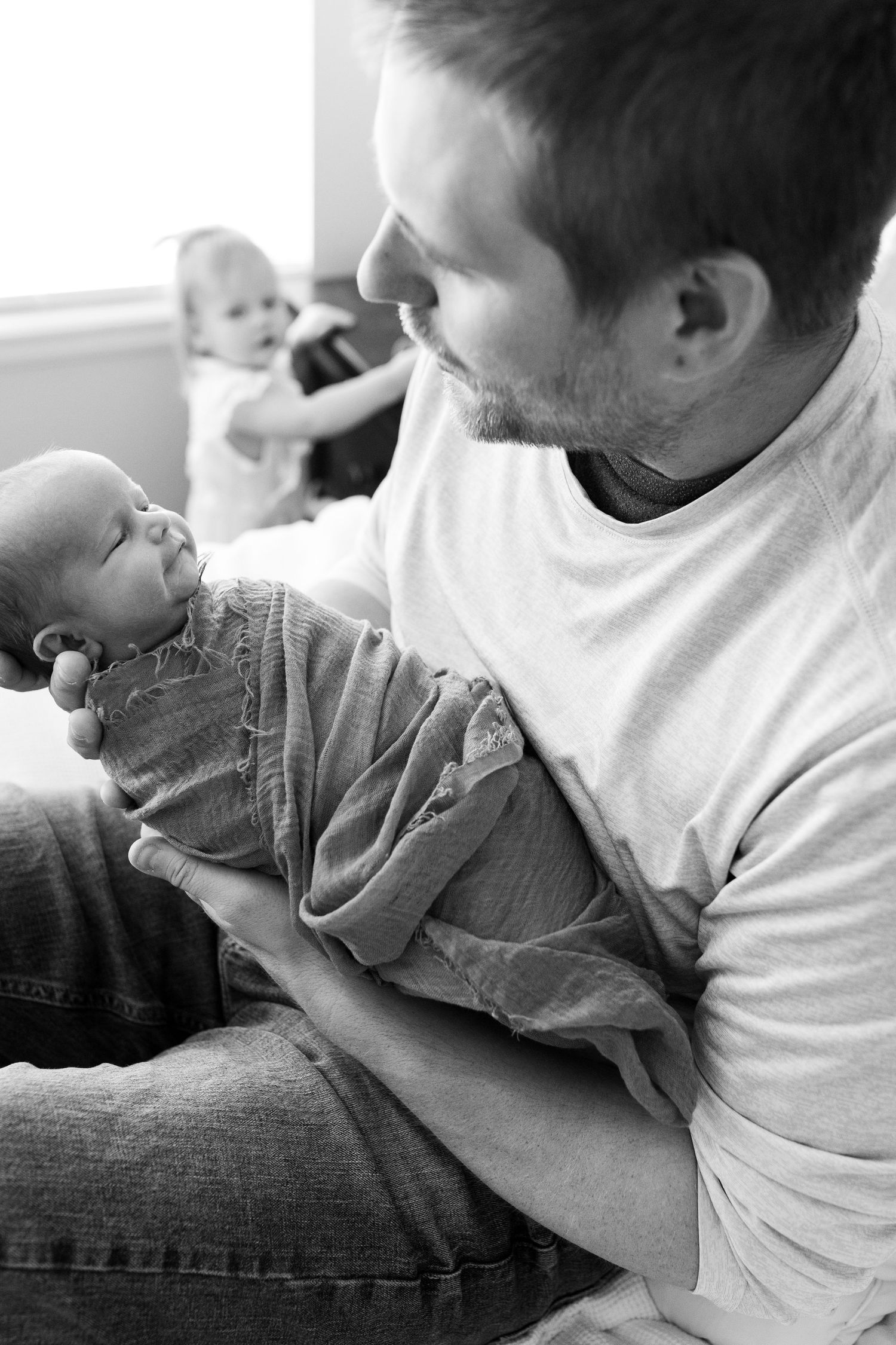 Father looking at newborn son during Northern Colorado newborn session with Erie, Colorado photographer