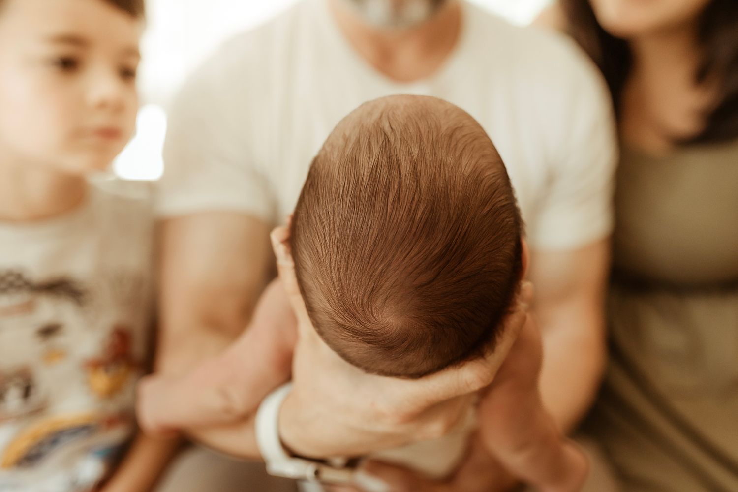 Dad cradles baby in his hands during a newborn session in Longmont, Colorado