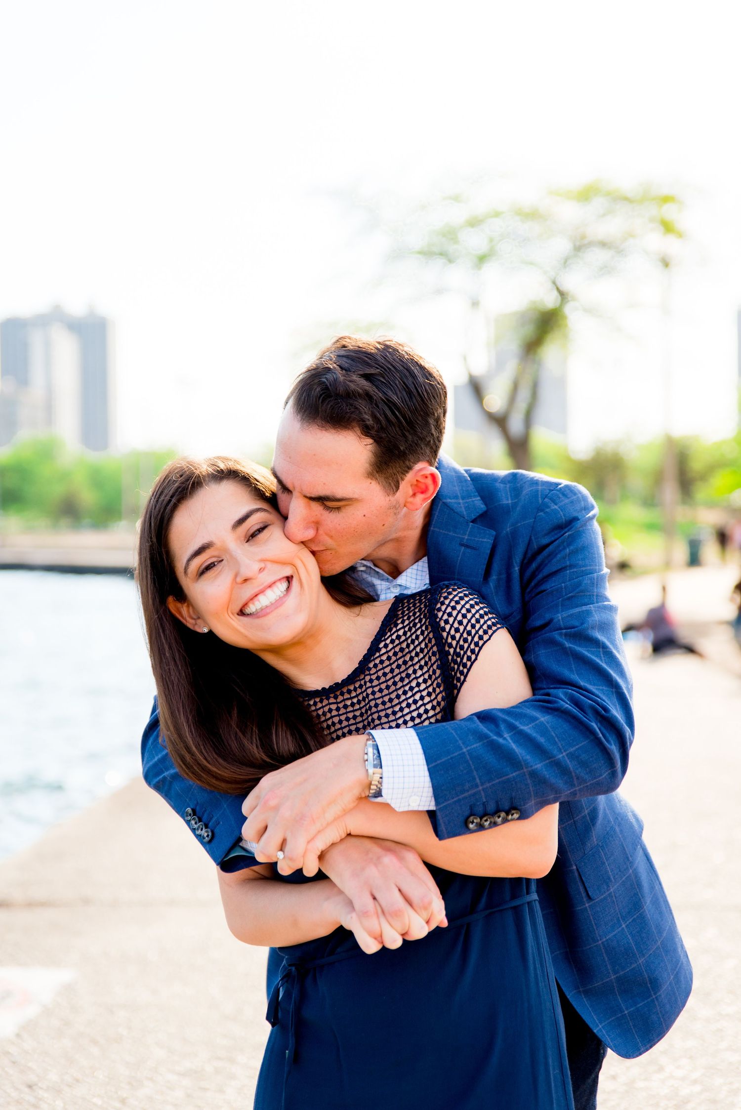 man kissing and hugging fiance after proposal at North Avenue Beach at sunset
