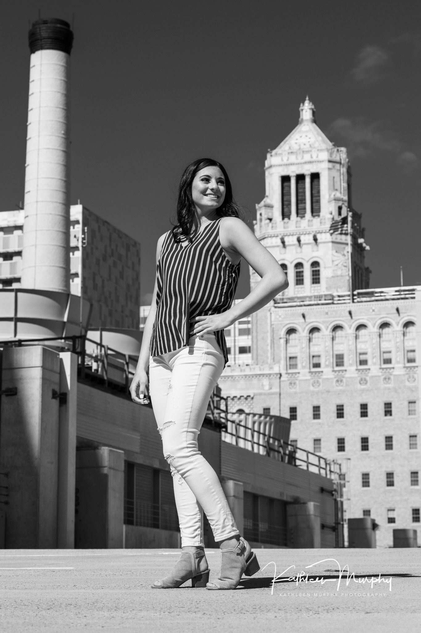 Black and white image of a senior girl in an urban setting, parking garage