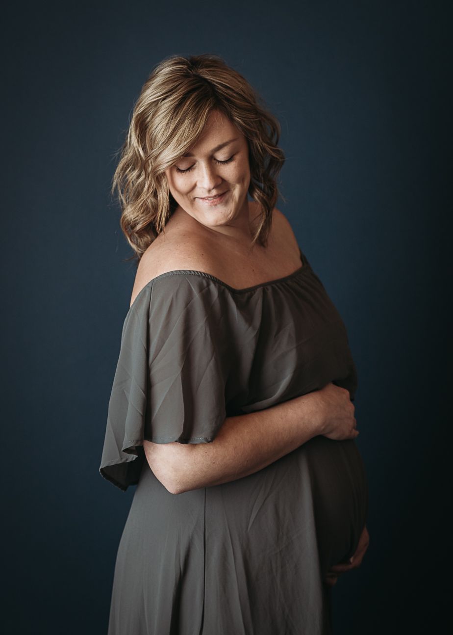 grey colored stone colored off the shoulder maternity dress hands on baby bump studio session