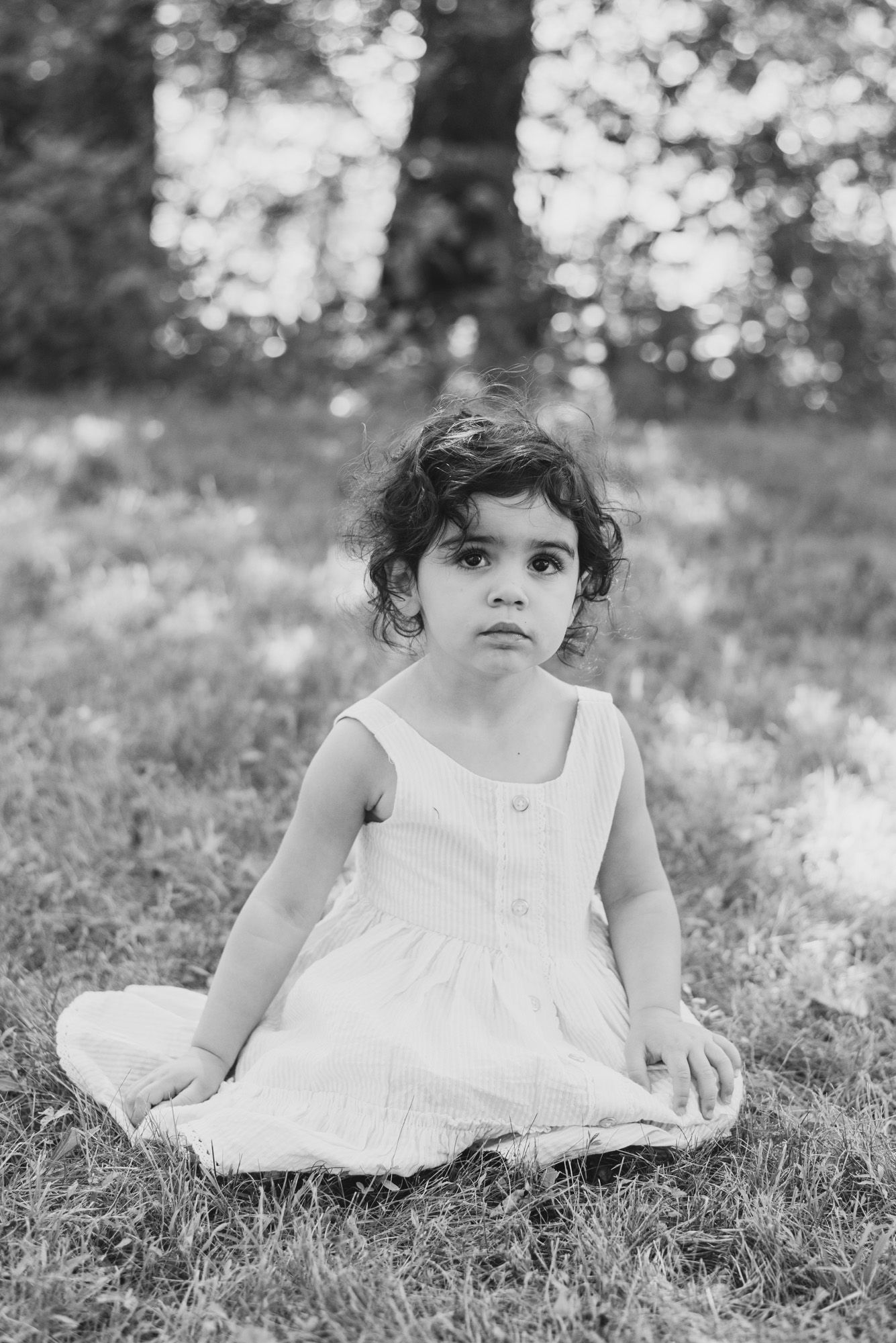 Toddler sitting in grass in black and white at Emmerling Park in Cheswick Pennsylvania