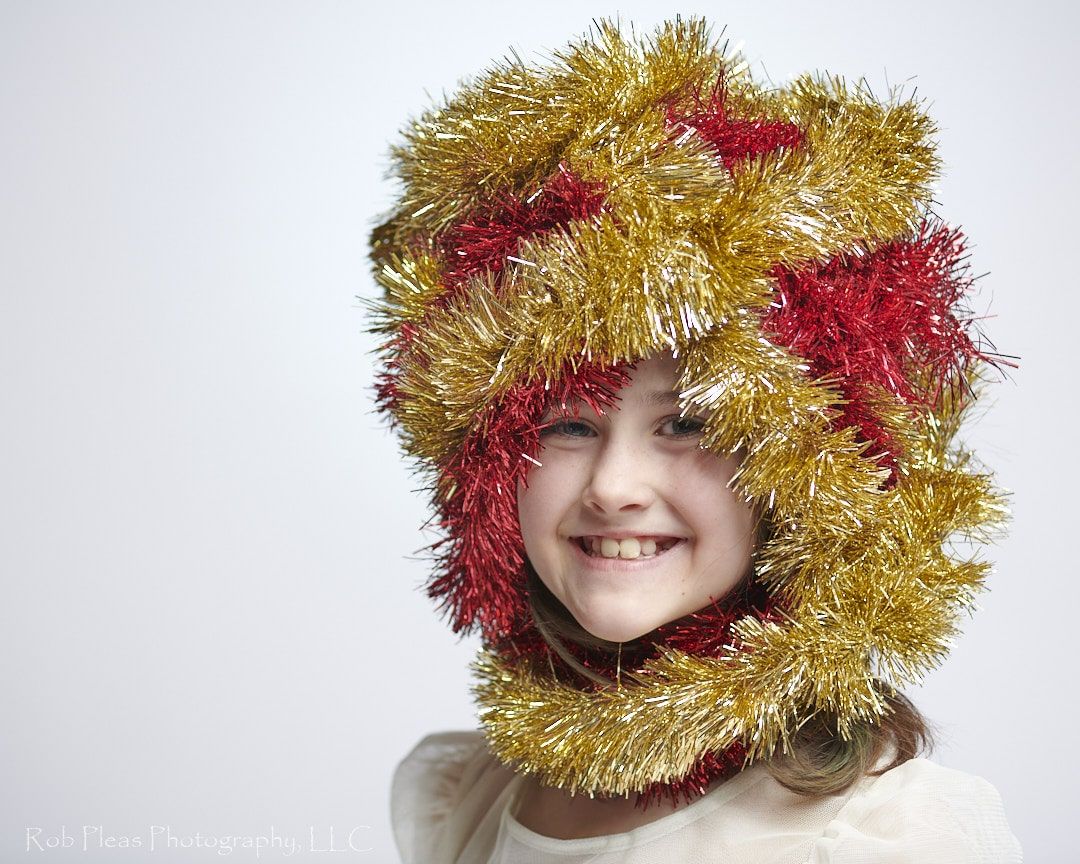 portrait of girl wearing headdress made of red and gold garland from the Christmas tree