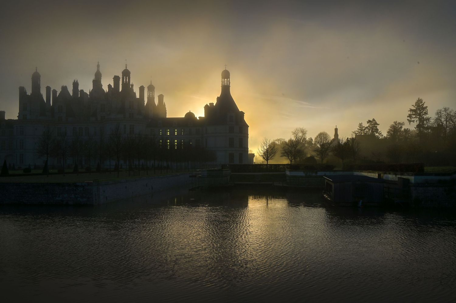 Vue depuis les douves et lever de soleil au château de Chambord / Région Centre Val de Loire