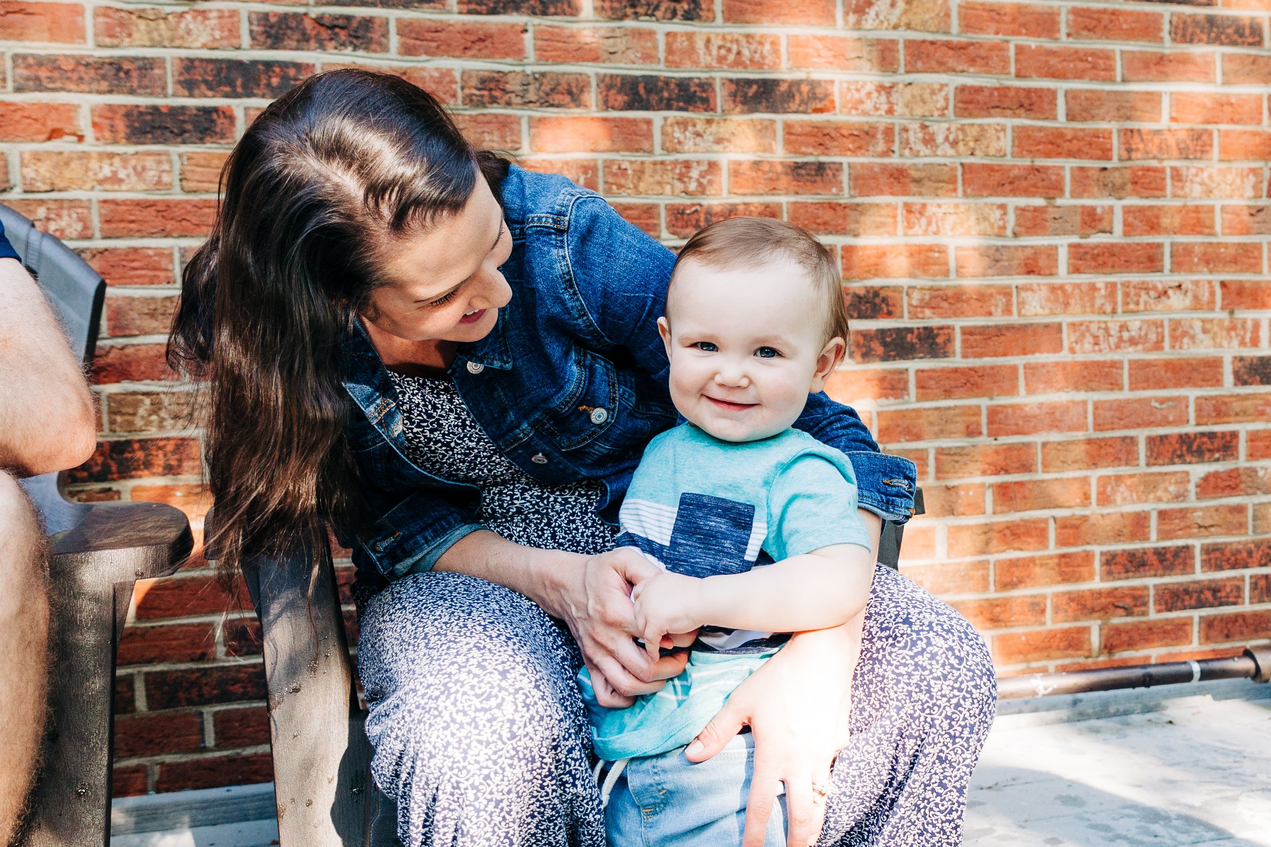 A mom hugging and smiling at her one year old son