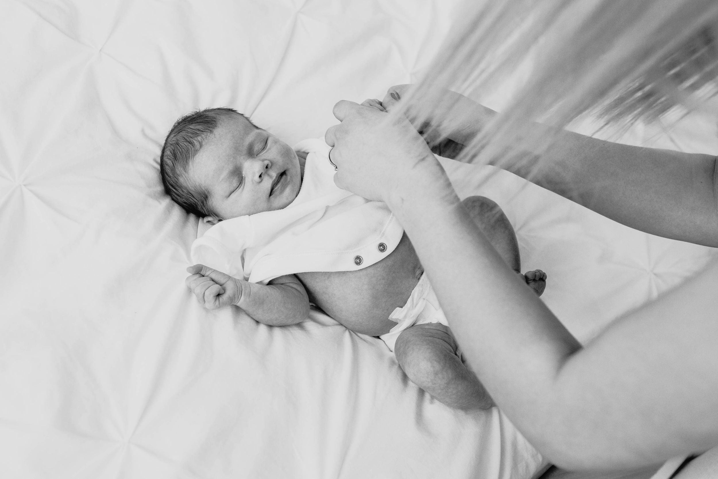 mum changing baby girl onesie