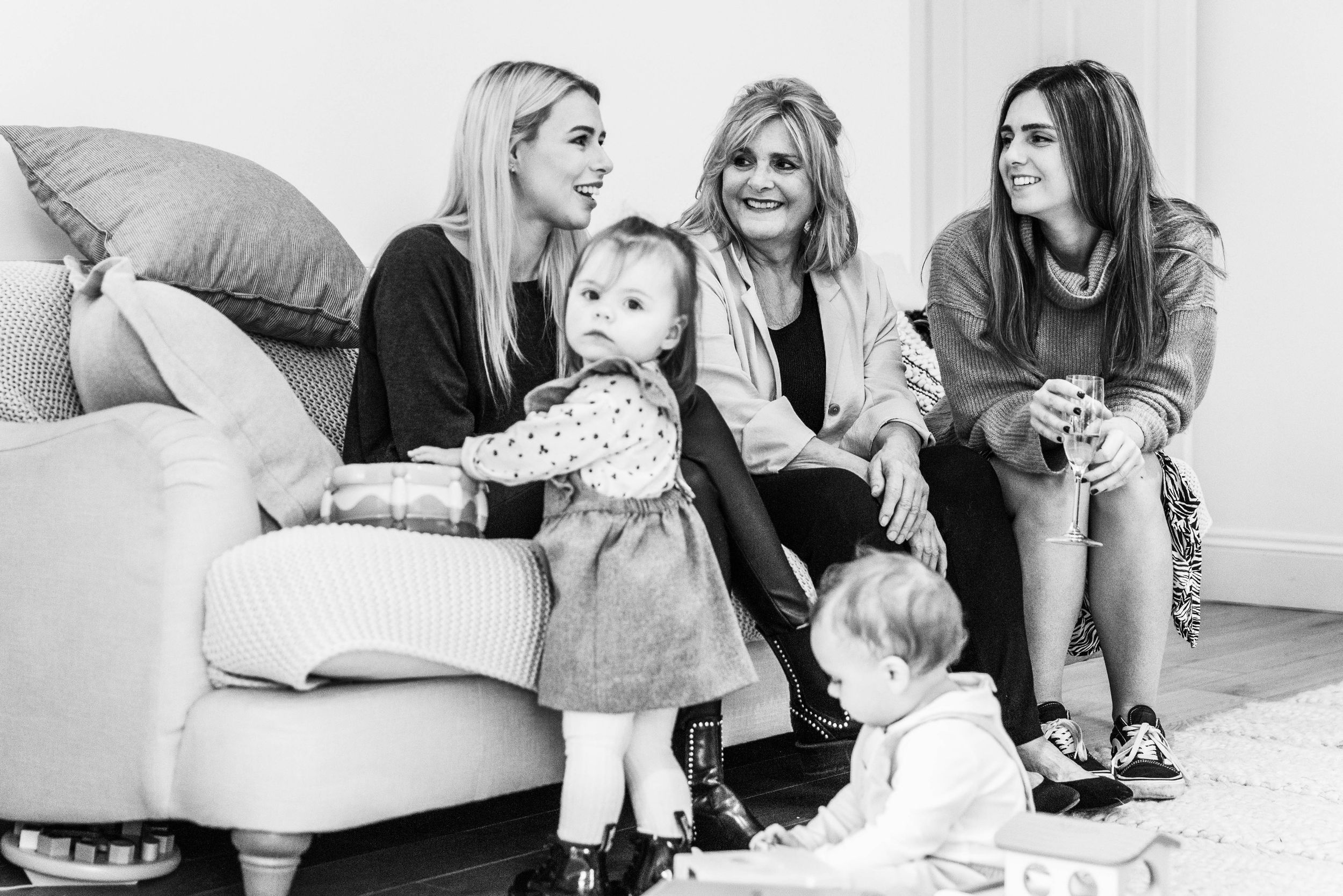 party guests sitting on sofa smiling talking