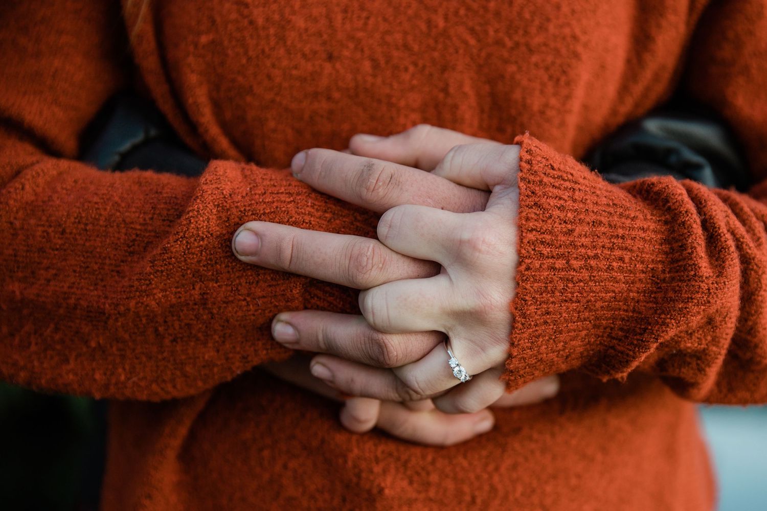 Holding hands and showing off the engagement ring