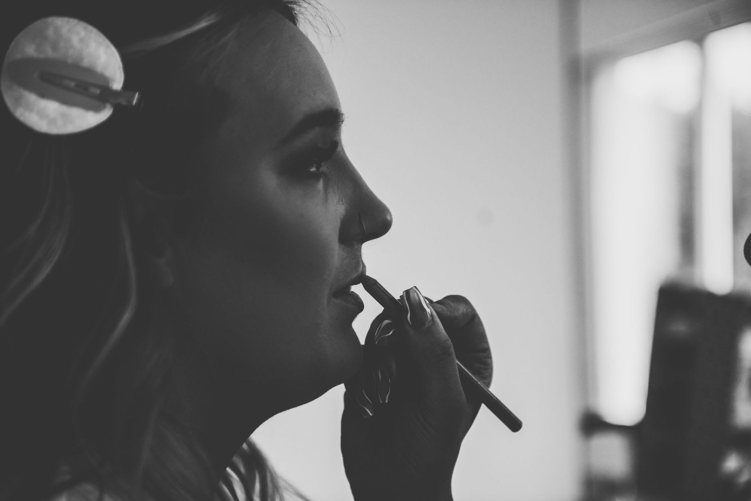 Bride having her makeup and hair done before a wedding. Wedding timeline guide.