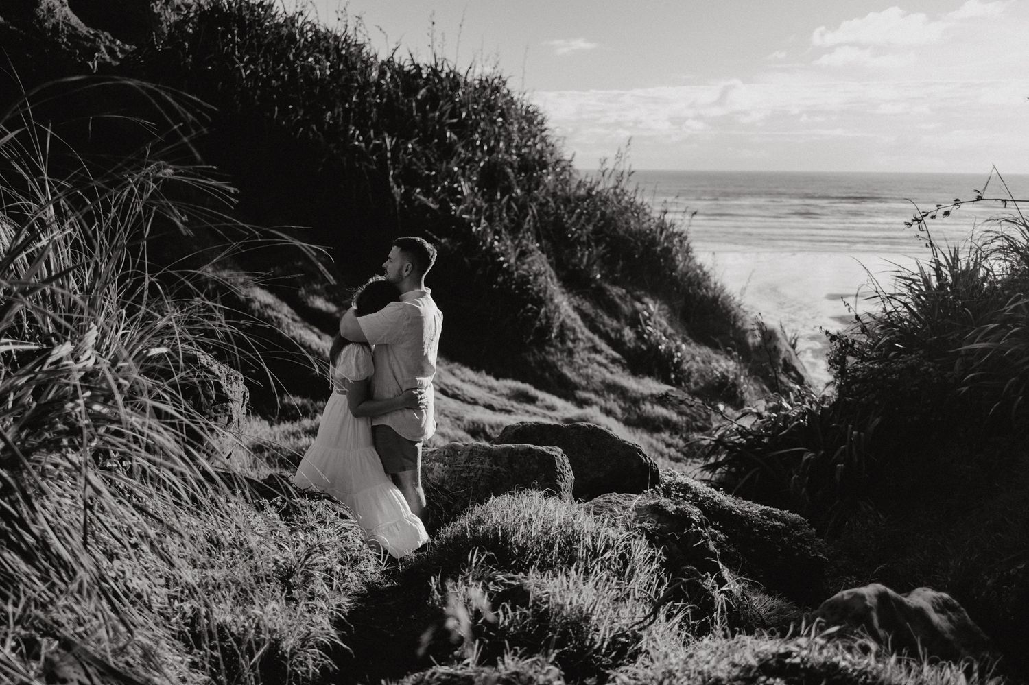 Couple on the hill in Karioitahi Beach for their engagement shoot with Apertured Media-Auckland Wedding Photographer