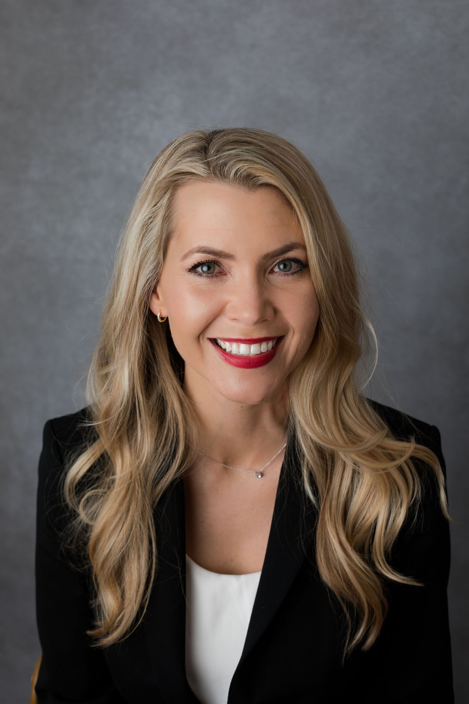 Business woman smiling for the camera for her professional business headshot to be used for business cards and social media.