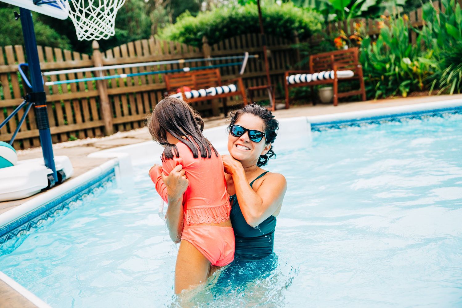 Mom playing with her daughter in their Charlotte, NC pool